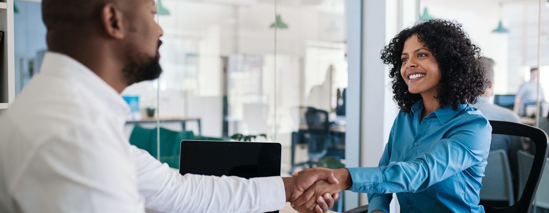 Image of two people in a interview environment shaking hands