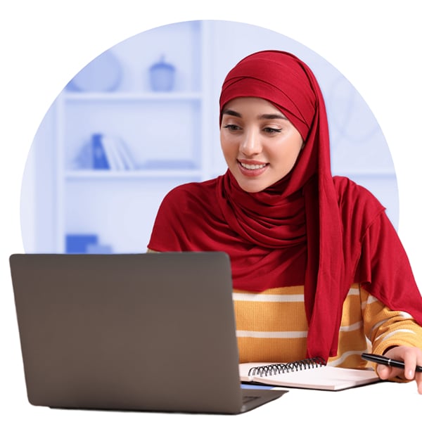 Smiling young woman in hijab working at laptop
